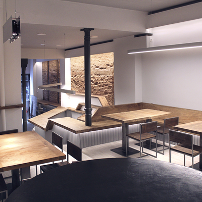 Zona comedor donde la barra se transforma en banco e iluminación ambiental