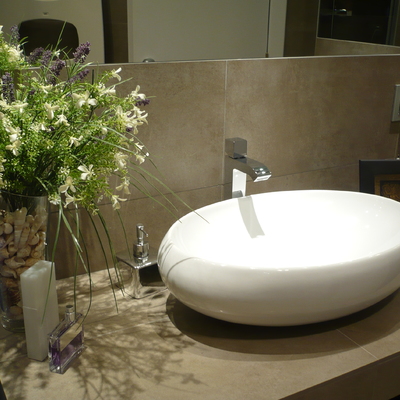 detalle de lavabo sobre encimera de obra volada a medida y revestida mismo material paredes