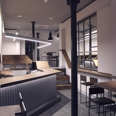 Entrada del restaurante con barra de madera continua e iluminación ambiental