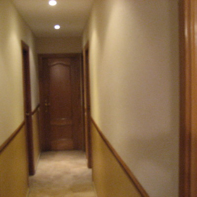 Es un pasillo pintado en dos tono las paredes y techo blanco