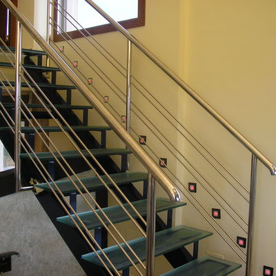 Escalera con peldaños de cristal y barandilla inox.