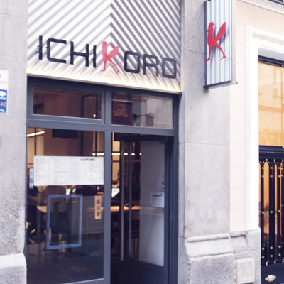 Fachada del restaurante, con señalética y puerta de entrada de cristal y acero