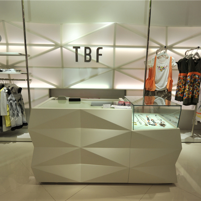 Diseño para tienda de moda con mesa expositiva y soporte de ropa, en Barcelona