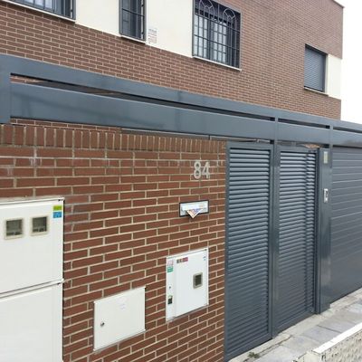 Frontal de hierro lacado con puerta peatonal de lama eliptica y puerta seccional en Ral 7016 Gris