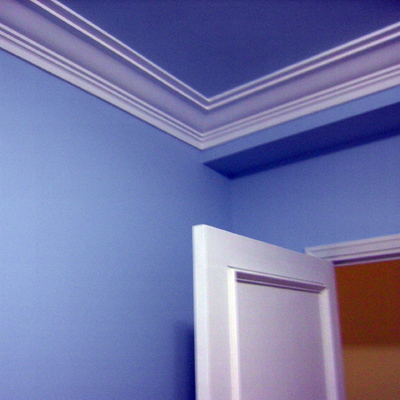 Habitación azul, moldura blanca y puerta lacada en blanco