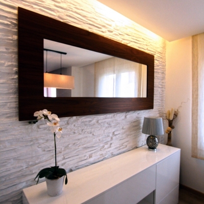 Mueble auxiliar del comedor con pared decorativa e iluminación indirecta.