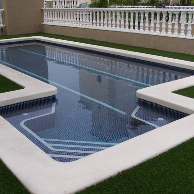 Piscina con zona SPA en la entrada y los bancos