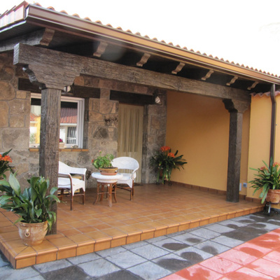 Porche rústico con paredes con piedra natural