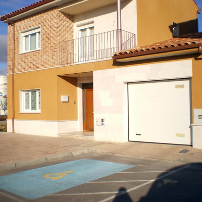 Puerta de entrada en pvc color madera, ventanas en PVC blanco, y puerta de garaje 