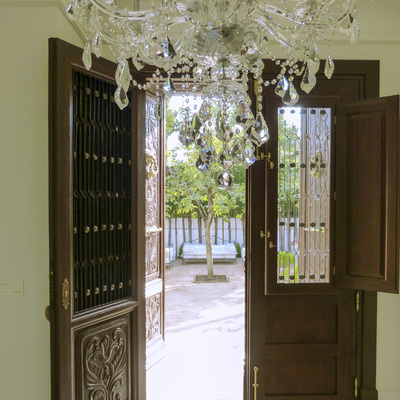 Puerta de madera con ventanas y rejas de forja con detalles dorados