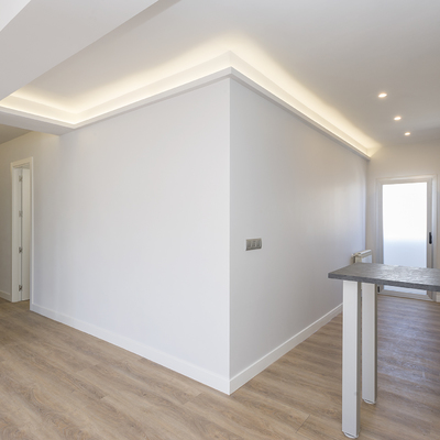 cocina abierta, salón y pasillo conectados por la iluminación LED en el techo