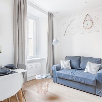 Salón contemporáneo con detalle en pared ladrillo blanco