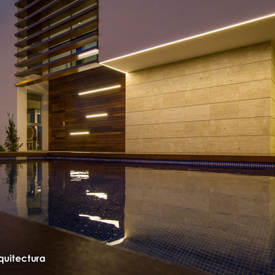 Vista nocturna de la fachada principal de la vivienda