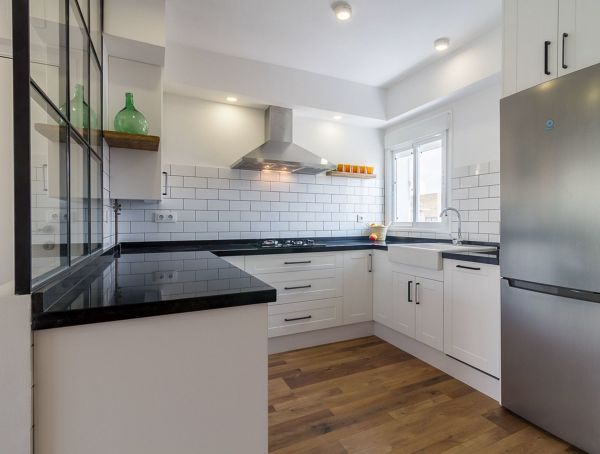 cocina moderna de planta abierta con azulejo tipo metro y porcelánico imitación madera en el suelo
