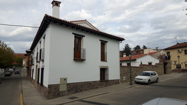 Fachada lateral con muro de patio de piedra