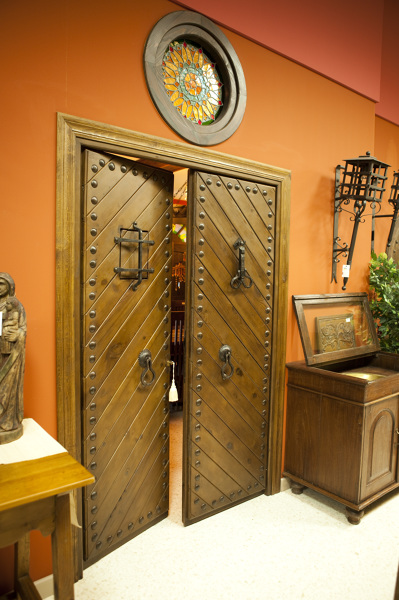 Puerta rústica de dos hojas con duelas en forma de espiga, mirilla, postigo y reja.