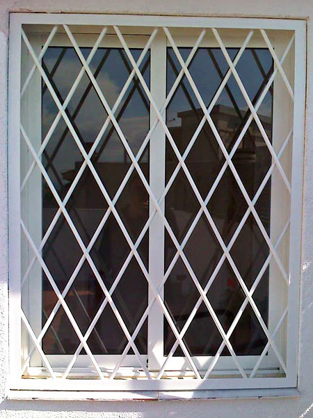 Rejas fijas en forma de rombo acabado blanco.