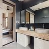 Baño en suite con revestimientos en negro y encimera de mármol