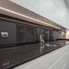 Cocina blanca con panel en vidrio negro
