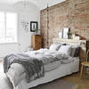 Dormitorio con pared ladrillo vista