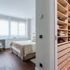 Dormitorio con vestidor y mueble de madera de DM a medida debajo de las ventanas