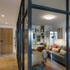 Recibidor con pared de cristal y mueble a medida