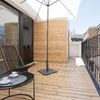 Terraza con suelo y paredes revestidas en madera apta para exteriores.