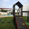 Zona de juegos infantil con columpios en jardín